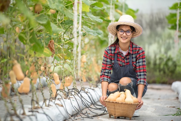 농장에서 butternut 스쿼시 수확에 행복 미소 농업 아가씨