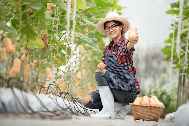 농장에서 butternut 스쿼시 수확에 행복 미소 농업 아가씨