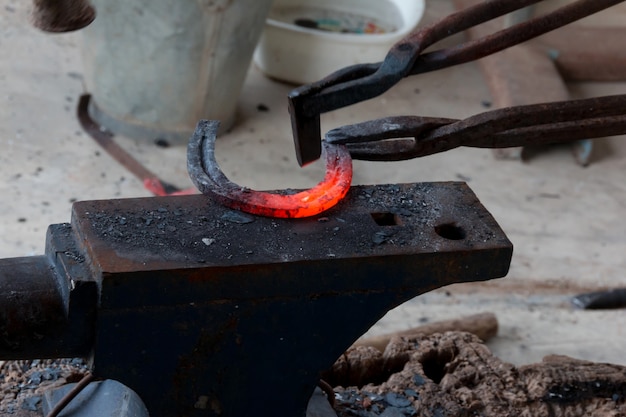 Farrier che fa a ferro di cavallo dallo stile antico