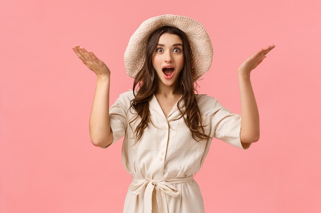 Fascinating news, congratulations. Amazed happy and ecstatic young feminine girlfriend in dress and hat, raising hands up sideways astonished and surprised of great thing happened, smiling