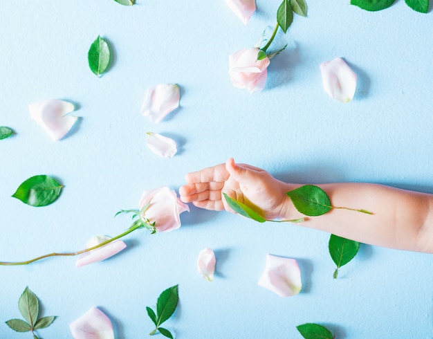 Fashion art  hand of a little child holding flowers