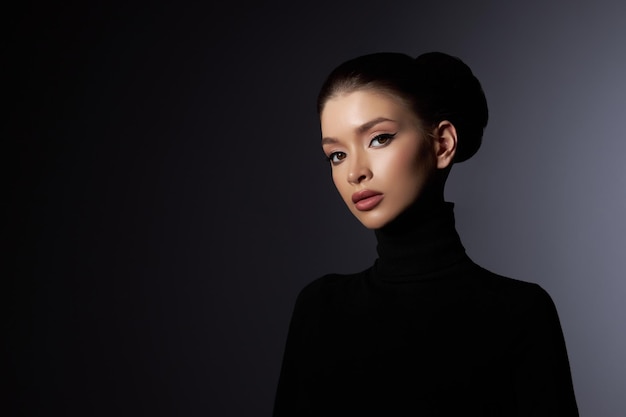 Fashion art studio portrait of beautiful elegant woman in black turtleneck Hair high beam perfect profile face Elegant beauty style Earrings in the ears