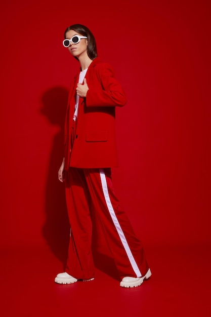 Fashion asian female model in red suit white boots and sunglasses