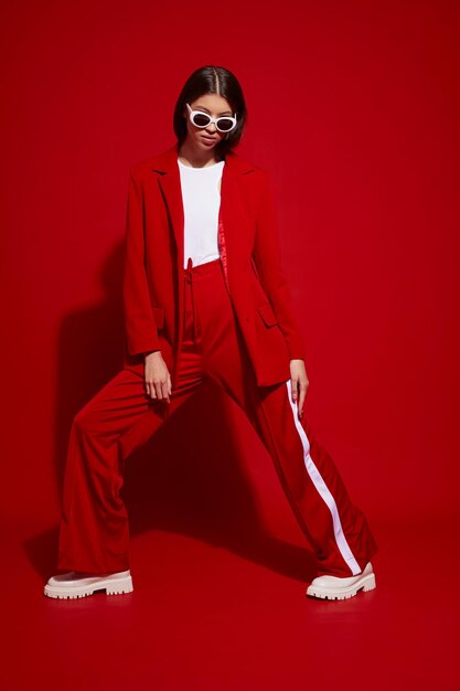 Fashion asian female model in red suit white boots and sunglasses