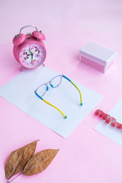 Concetto di moda e bellezza sdraiato piatto con occhiali ovali accessori da donna su sfondo rosa presentazione del prodotto di idee concettuali minimaliste