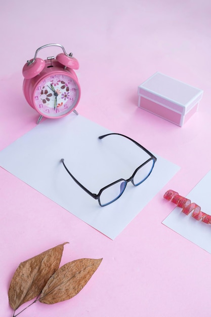 Concetto di moda e bellezza sdraiato piatto con occhiali quadrati accessori da donna su sfondo rosa presentazione del prodotto di idee concettuali minimaliste Foto Premium
