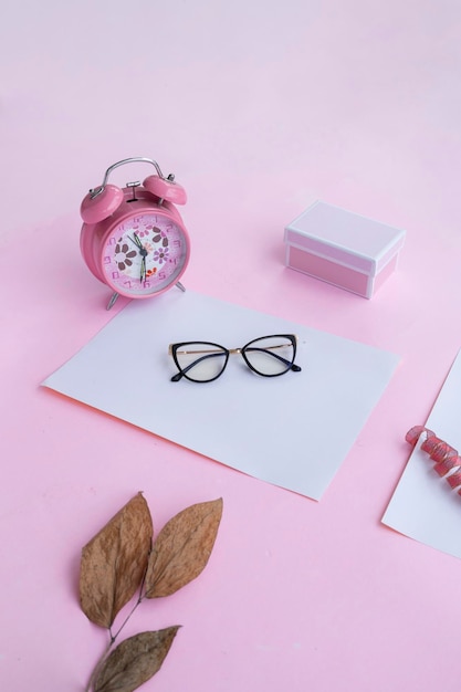 Fashion and beauty concept lying flat with square glasses women's accessories on pink background