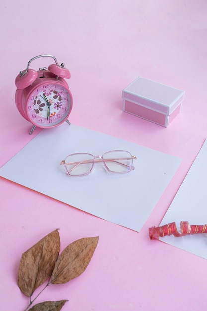 Fashion and beauty concept lying flat with square glasses women's accessories on pink background