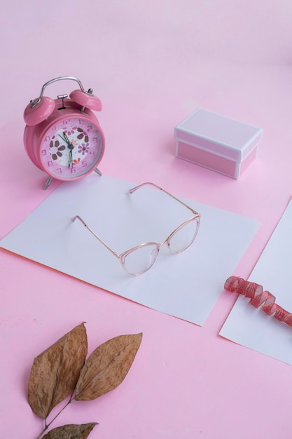 Fashion and beauty concept lying flat with square glasses women's accessories on pink background