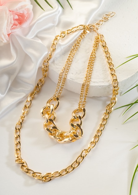 Fashion bijouterie - a large double gold chain on a white stand, close up