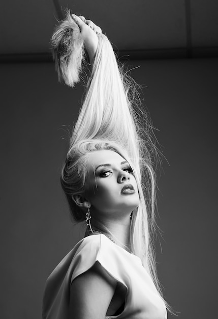 Fashion black and white portrait beautiful blonde holding her hair