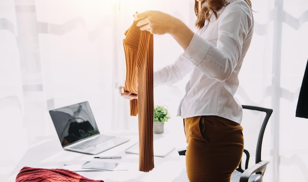 Fashion blogger-concept Jonge vrouwen die kleding verkopen op videostreamingStartup kleine bedrijven MKB met behulp van smartphone of tablet ontvangen en inchecken in de studio