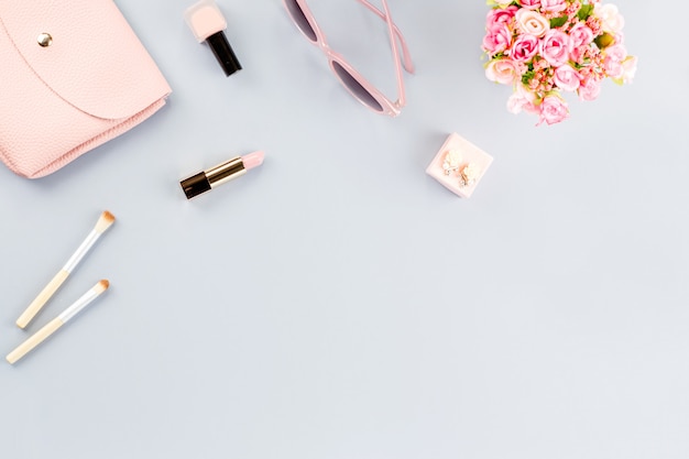 Мода блогера рабочего пространства плоская планировка с насосами, косметикой, кошельком, ежедневником и цветами.