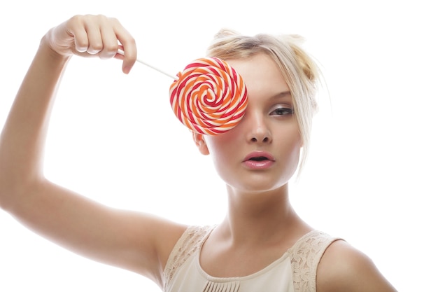 Fashion blond woman holding lollipop, posing against white background