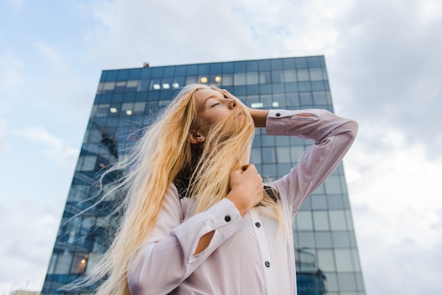 Модная блондинка в позе блузки на открытом воздухе
