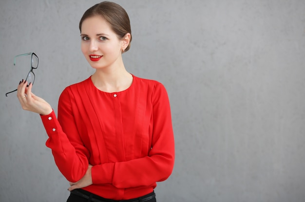 Fashion business woman with a red shirt and glasses portrait, holding sunglasses in his hand