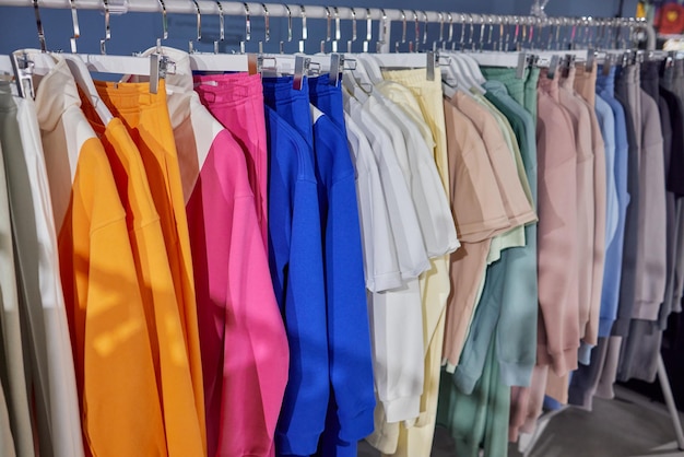 Fashion clothes on clothing rack bright colorful cotton shirts
on hanger in boutique shop