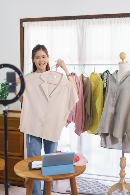 Fashion clothes merchant concept Female seller show and present detail of shirt on live streaming