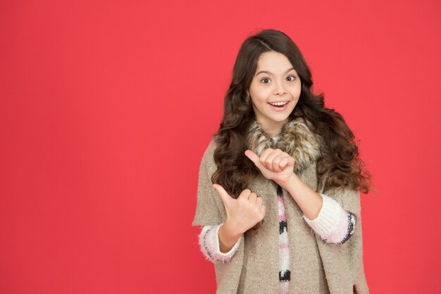 Fashion concept. Best shampoos and conditioners for lush hair. Nourish dull and damaged hair. Girl long curly hair. Little beauty smiling red background. Happy childhood. Beautiful model kid.