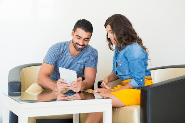 Fashion couple sitting together and using a tablet