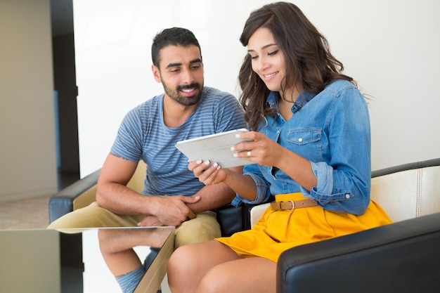 Fashion couple sitting together and using a tablet