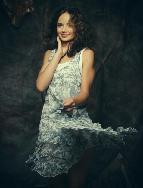 Fashion curly model sitting on a stool in drama decoration