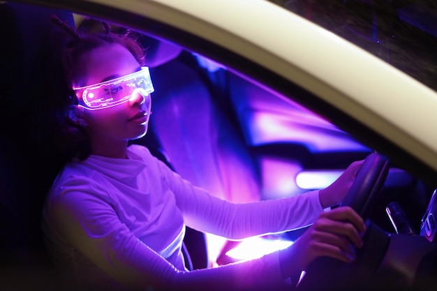 ファッションサイバーパンクの女の子は、将来のデジタルガラスの未来の技術でスーパーカーのアジアの女性を運転します