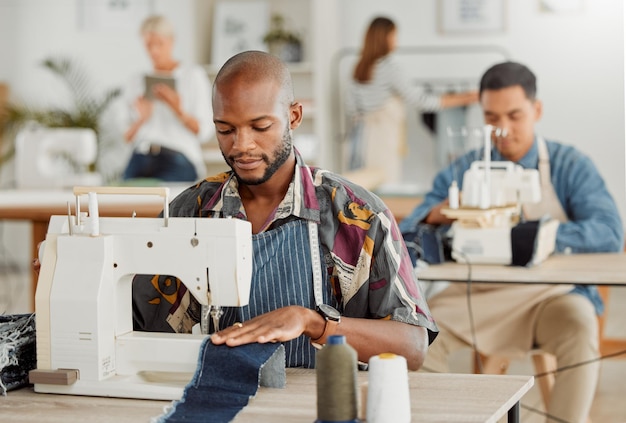 Fashion design and stylist or a young designer working with sewing machine Busy creative business employee creating new trendy and fashionable clothes Man at work with material in a workshop