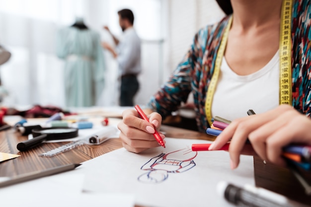 Fashion designer drawing model on paper.