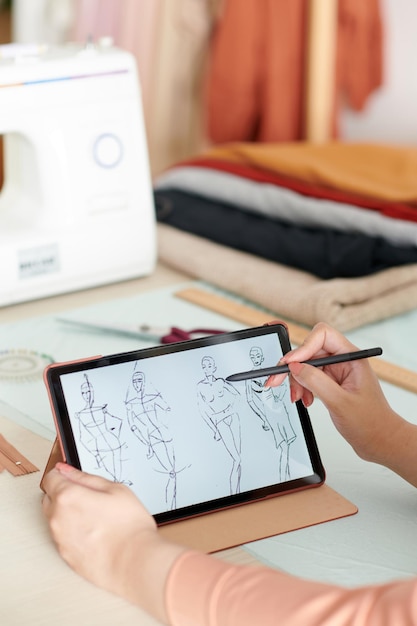 Fashion designer drawing sketches for new collection on tablet computer