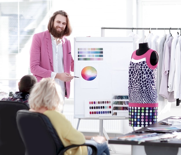 Foto stilista che mostra ai colleghi la tavolozza dei colori per la nuova collezione