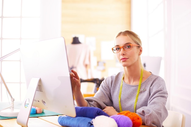 Photo fashion designer using tablet computer in the studio