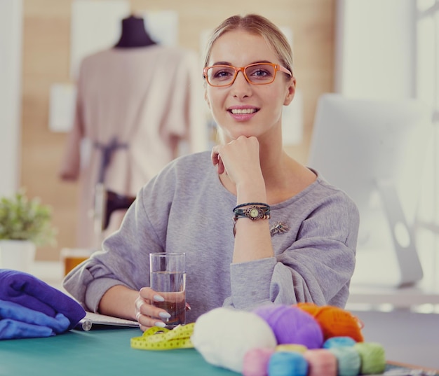 Foto donna stilista che lavora ai suoi disegni in studio