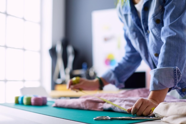 写真 スタジオで彼女のデザインに取り組んでいるファッションデザイナーの女性