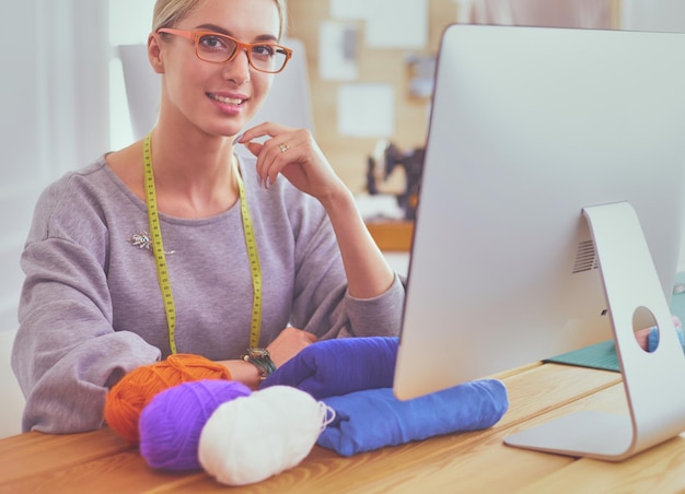 Fashion designer woman working in studio sitting at thhe desk