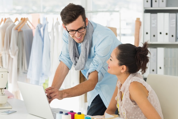 Fashion designers using laptop in studio