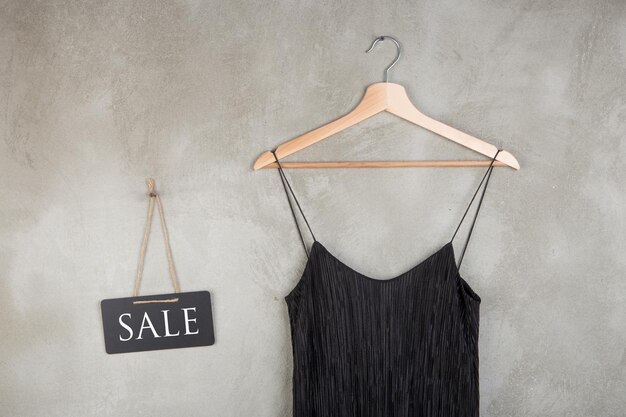 텍스트 판매와 옷걸이에 아름 다운 작은 검은 드레스와 패션 할인 개념 칠판
