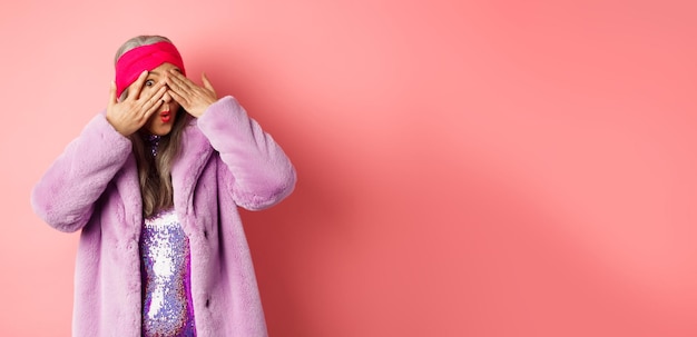Fashion en shopping concept Stylish Aziatische hipster oma in paarse outfit die haar ogen bedekt persoon