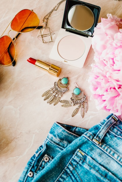 Fashion flat lay. Pink peony flower with jeans, shoes and accessories