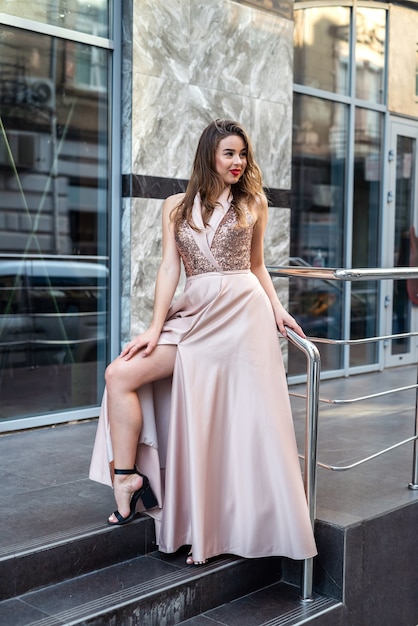 Fashion full-length portrait pretty lady in attractive ball gown dress at city street. Lifestyle