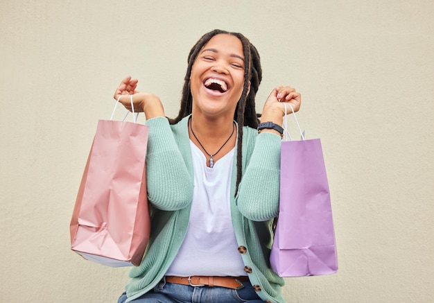 Photo fashion funny or happy black woman with shopping bag gift or smile in retail therapy with wall mockup freedom relax or excited customer laughing with clothes or products on discounted sales offer