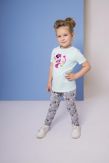 Fashion girl in stylish clothes on colored wall background. Autumn bright clothes on children, a child posing on a colored purple pink background. Russia, Sverdlovsk, 6 April 2019