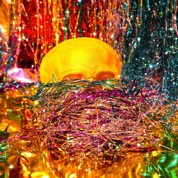 Fashion gold skull on tinsel mask and tinsel background
