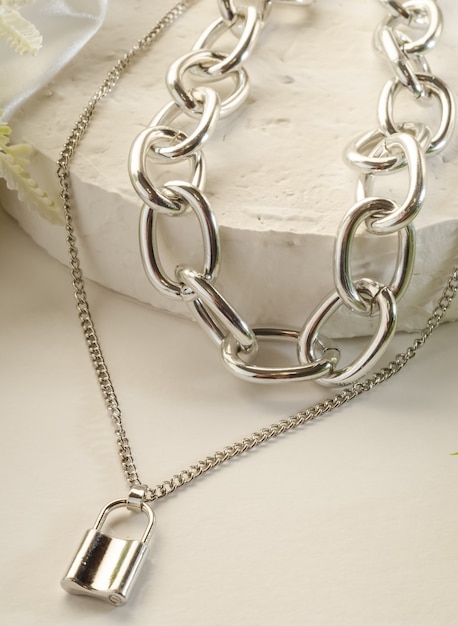 Fashion jewelry - large silver double chain with a lock on a white stand