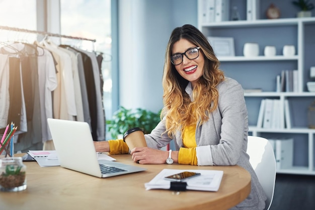 Fashion laptop and portrait of woman designer with coffee and happy for startup company growth in sales Ecommerce retail and working small business entrepreneur of a boutique in a office