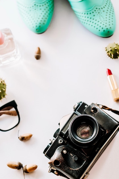 Le scarpe di moda in pelle si trovano con la macchina fotografica, gli occhiali e le ghiande.