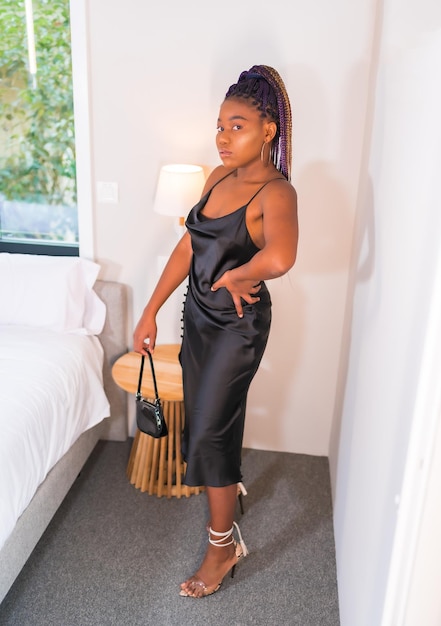 Fashion lifestyle of a black ethnic girl in a black dress Portrait of the pretty girl