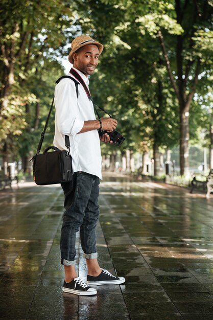 Fashion man in park with camera