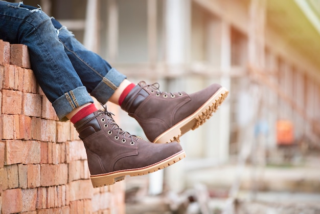 Premium Photo | Fashion men's legs in jeans and brown boots for man  collection.