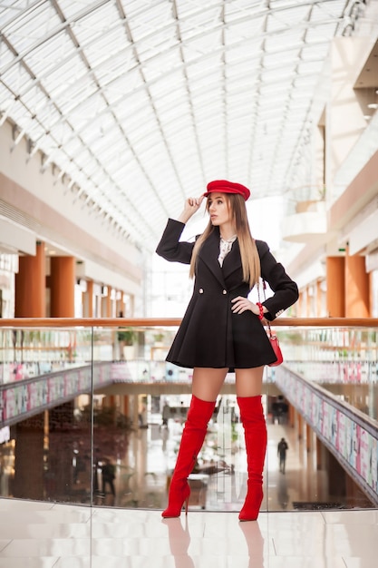 Foto modello di moda pubblicità negozio di moda o centro commerciale. bruna alla moda posa professionalmente per la macchina fotografica al posto delle boutique. concetto di consumismo, vendita, shopping. copia spazio per il sito